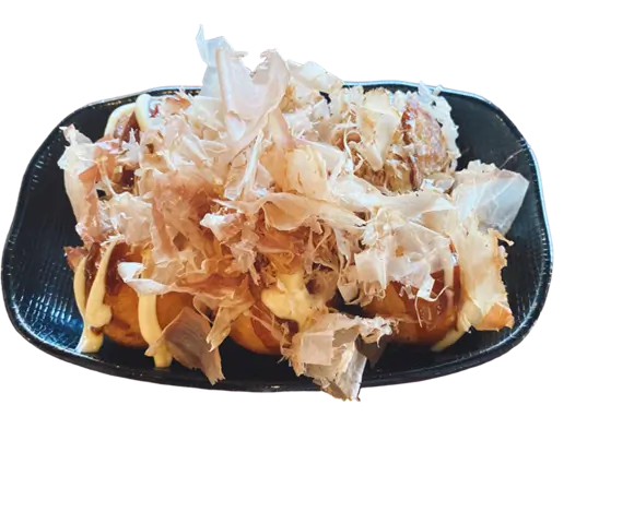 Takoyaki are small, round fried dough balls filled with diced octopus, topped with shredded seaweed, mayonnaise, and a savory sauce at Torakichi Ramen, a Japanese Ramen restaurant in Palm Springs